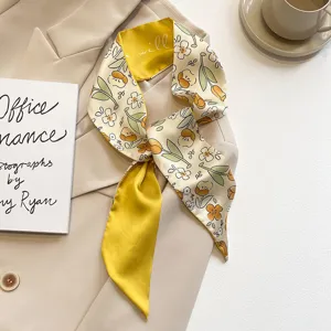 Close-up view of a vintage French-style skinny scarf featuring yellow tulip floral prints