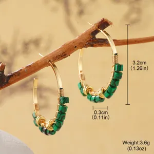 Macro view of handmade ethnic gold hoop earrings with green malachite stone beads