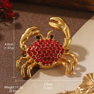 Detailed view of vintage gold crab brooch with red crystals showing size and weight info