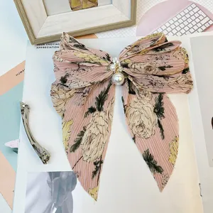 Gros plan détaillé d'une grande barrette à cheveux nœud fleuri en mousseline plissée