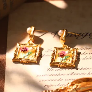Detailed view of French vintage enamel rose earrings decorated with natural pearls