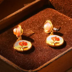 Gros plan détaillé de boucles d'oreilles vintage en émail rose et perles naturelles