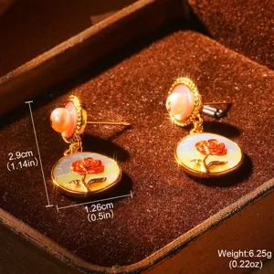 Vue détaillée boucles d'oreilles rose émaillée vintage avec perles sur écrin brun.