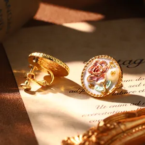 Detailed macro view of vintage French style enamel flower clip-on earrings with pearl