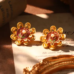 Detail view of vintage French courtly style earrings with red enamel and natural pearl.