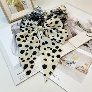 Detail view of vintage satin bow hair clips featuring elegant white pearl accents