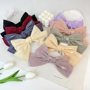 Detailed macro view showing the texture of elegant silk bow hair clips in various pastel colors