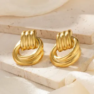 Makroansicht von gold gefalteten Edelstahl-Ohrringen mit eleganter Metallstruktur