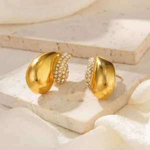 Makro-Detailansicht goldener Edelstahl-Ohrstecker mit schimmernden Kristallakzenten