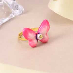 Detailed view of a gold-toned ring featuring a vibrant pink butterfly with pearl center