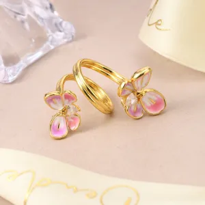 Detailed view of an elegant gold adjustable ring featuring pink enamel flowers.