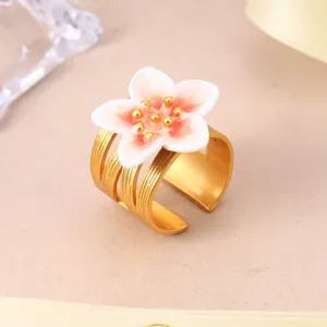 Detailed view of elegant gold adjustable ring featuring a pink and white floral design.