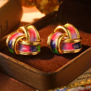 Detail view of rainbow enamel stud earrings with golden textured edges