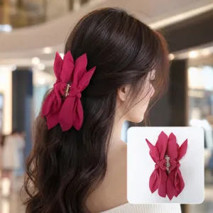 Fuchsia fabric bow hair claw clip detail showing placement on long wavy hair