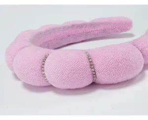 Macro view of a soft pink sponge cloud headband with elegant rhinestone accents