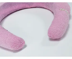 Detalle en primer plano de una diadema de esponja rosa con elegantes perlas blancas