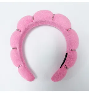 Close-up of pink puffy cloud sponge headband with sparkling rhinestone accents for face washing