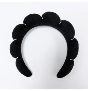 Macro view of black sponge fabric texture and shimmering rhinestone accents on headband