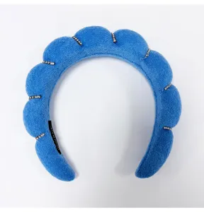 Detailed view of a blue padded cloud headband with sparkling rhinestone accents