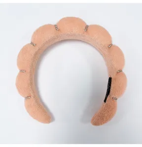 Detailed macro shot of peach cloud sponge headband with sparkling rhinestone accents