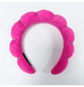 Close-up detail of a plush pink padded cloud headband with sparkling rhinestones