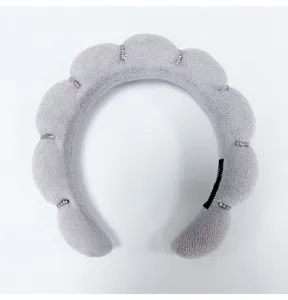 Detail of light grey sponge headband with cloud design and sparkling rhinestone accents
