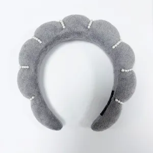 Primer plano de diadema de esponja nube gris con perlas para un look elegante de copa alta.
