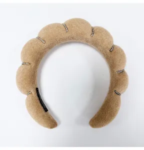 Detailed macro view of tan cloud-shaped sponge headband with rhinestone accents and soft texture