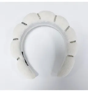 Macro detail of a white cloud padded sponge headband with elegant rhinestone bars