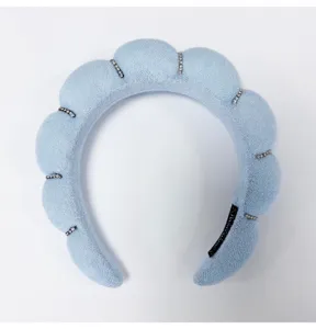 Close-up of light blue cloud sponge headband with sparkling rhinestone details