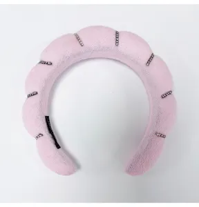 Close-up detail of a pink cloud-style sponge headband decorated with elegant rhinestone stripes