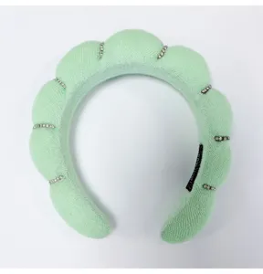 Close-up of a mint green cloud padded headband featuring elegant rhinestone strips.