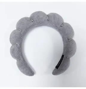Detailed view of a gray cloud-shaped sponge headband with sparkling rhinestone accents.