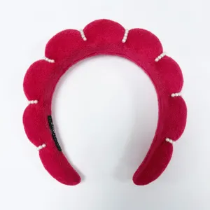Primer plano de diadema acolchada roja en forma de nube decorada con pequeñas perlas