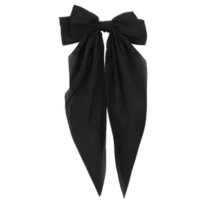 Primer plano de un gran lazo para el pelo de gasa negra con cintas largas y elegantes