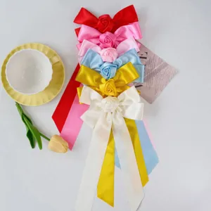 Detail view showing six colorful handmade satin ribbon bow hair clips with rose flower centers