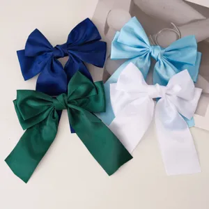 Detailed view of sweet satin ribbon bow hair clips in multiple candy colors