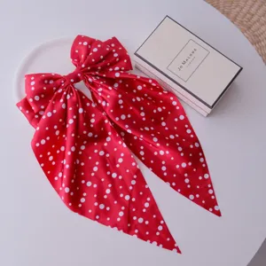 Detailed shot of large red polka dot bow hair clip with silky streamers