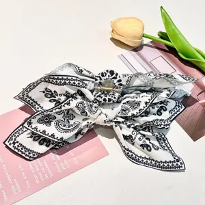 Close-up of large paisley print fabric bow hair claw clip with detailed patterns