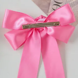 Detailed back view of a pink satin ribbon bow hair clip with silver metal alligator clip