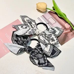 Detail of large paisley print fabric hair bow accessories with black elastic ties