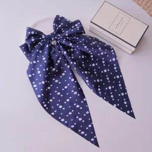 Elegant navy blue hair clip with large polka dot bow and long silk-like streamers