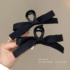 Close-up of black ribbon bow hair claw clips with elegant Hepburn style