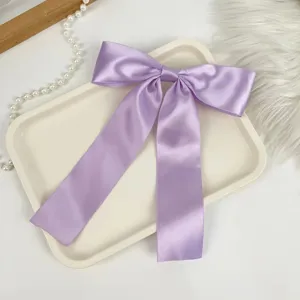 Detailed macro view of a lavender satin bow hair clip with long elegant flowing ribbons