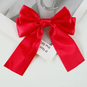 Detailed shot of a vibrant red satin ribbon bow hair clip for hair styling