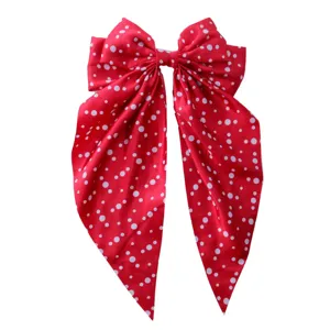 Elegant red polka dot oversized bow hair clip with long silky ribbons for women.