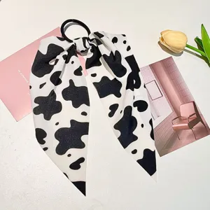 Close-up of the black and white cow print fabric bow hair tie with smooth texture