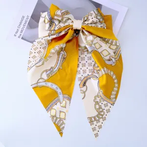Close-up of the elegant yellow silky bow hair clip with a vintage chain-link print
