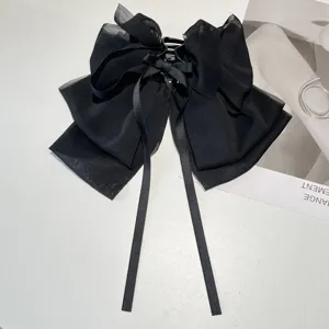 Macro view of a black textured chiffon bow hair claw clip with long elegant ribbons