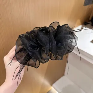 Close-up of black mesh ruffle hair claw clip with delicate feather accents for hair styling